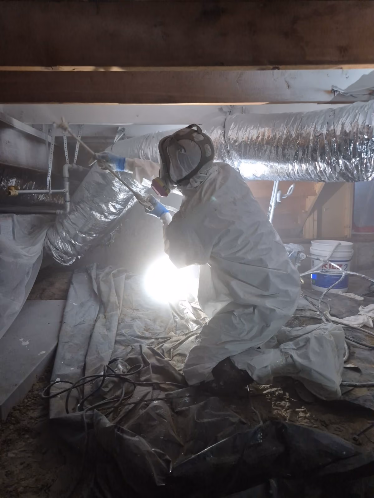 Technician working under a work light at a water loss