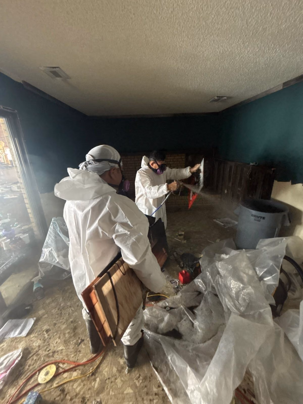 Technicians treating a contained room during mold remediation