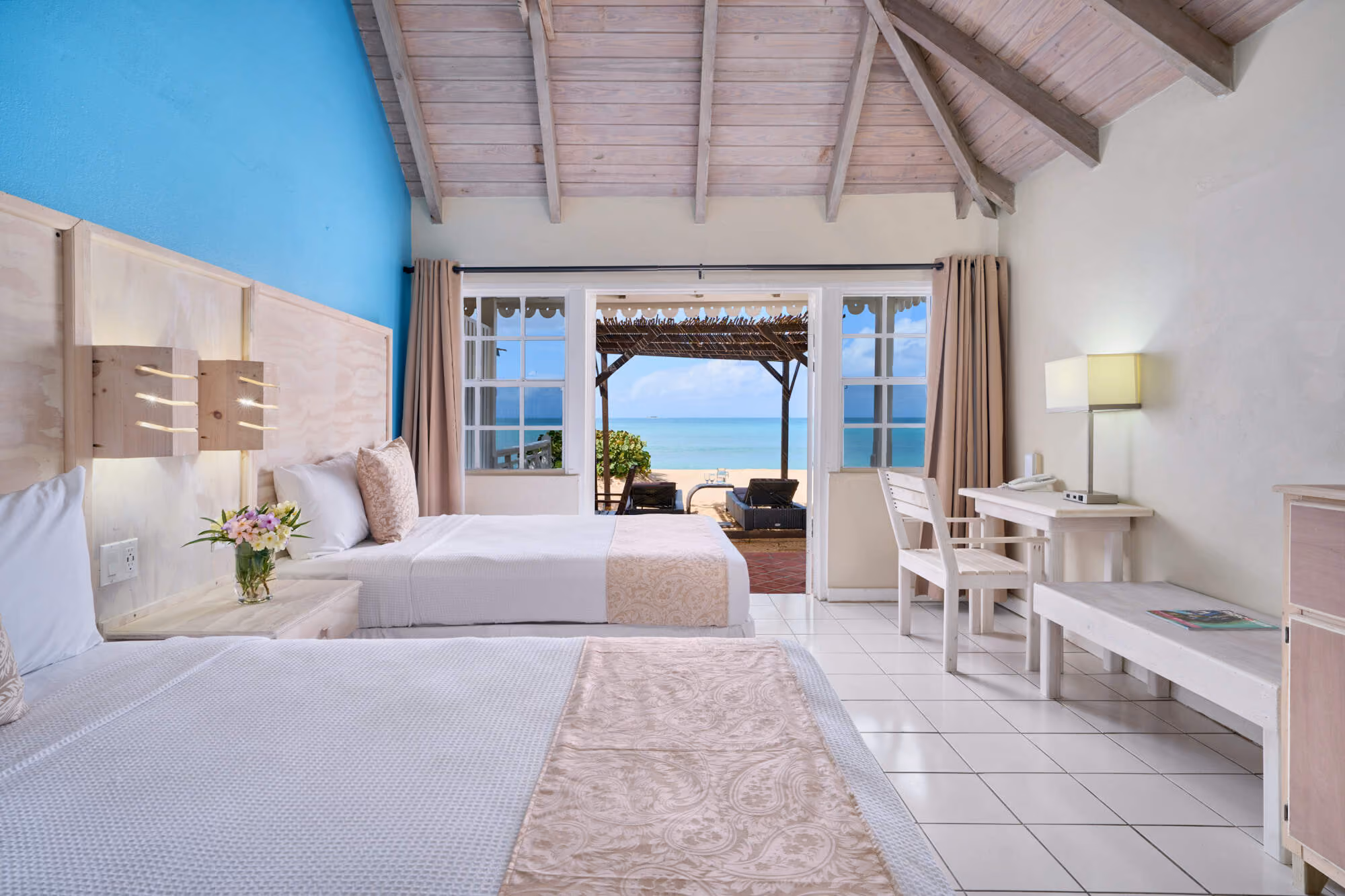 Light-filled cottage interior in soft blue and white with sea view, Hawksbill