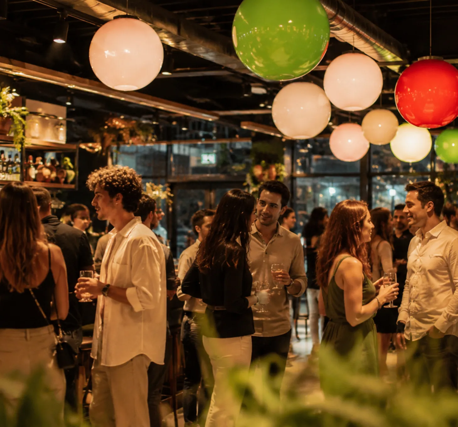 Des personnes discutent et tiennent des verres dans un bar animé aux lumières colorées.