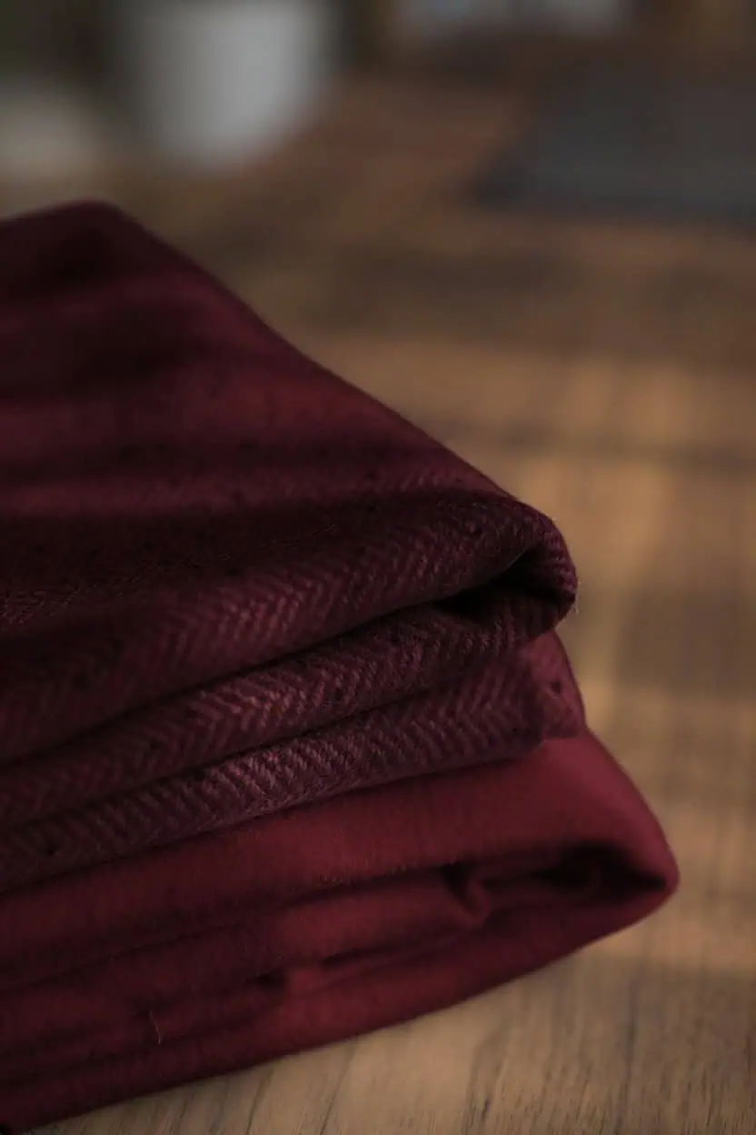 A pair of ruby-red cashmere-blend scarves folded side by side.