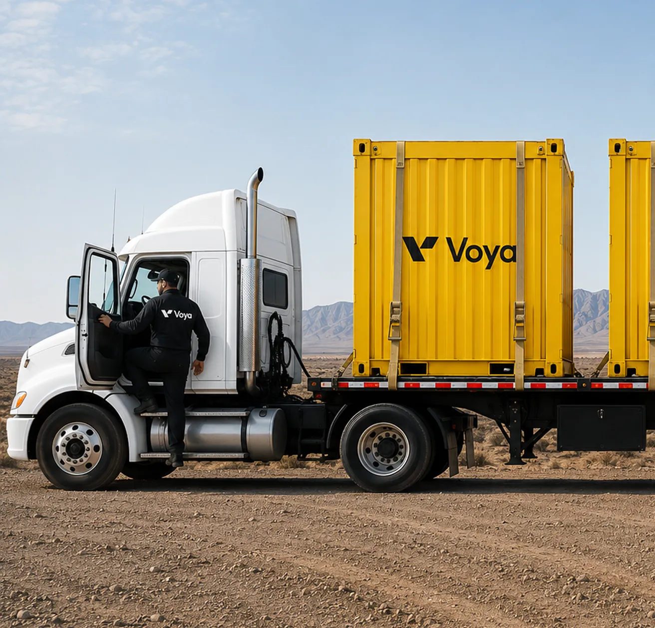 Driver in black Voya outfit entering white semi truck hauling yellow containers in desert area.