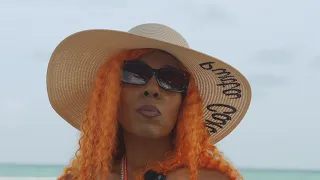 Woman in a wide-brim sun hat and sunglasses smiling on a Caribbean beach, video thumbnail.