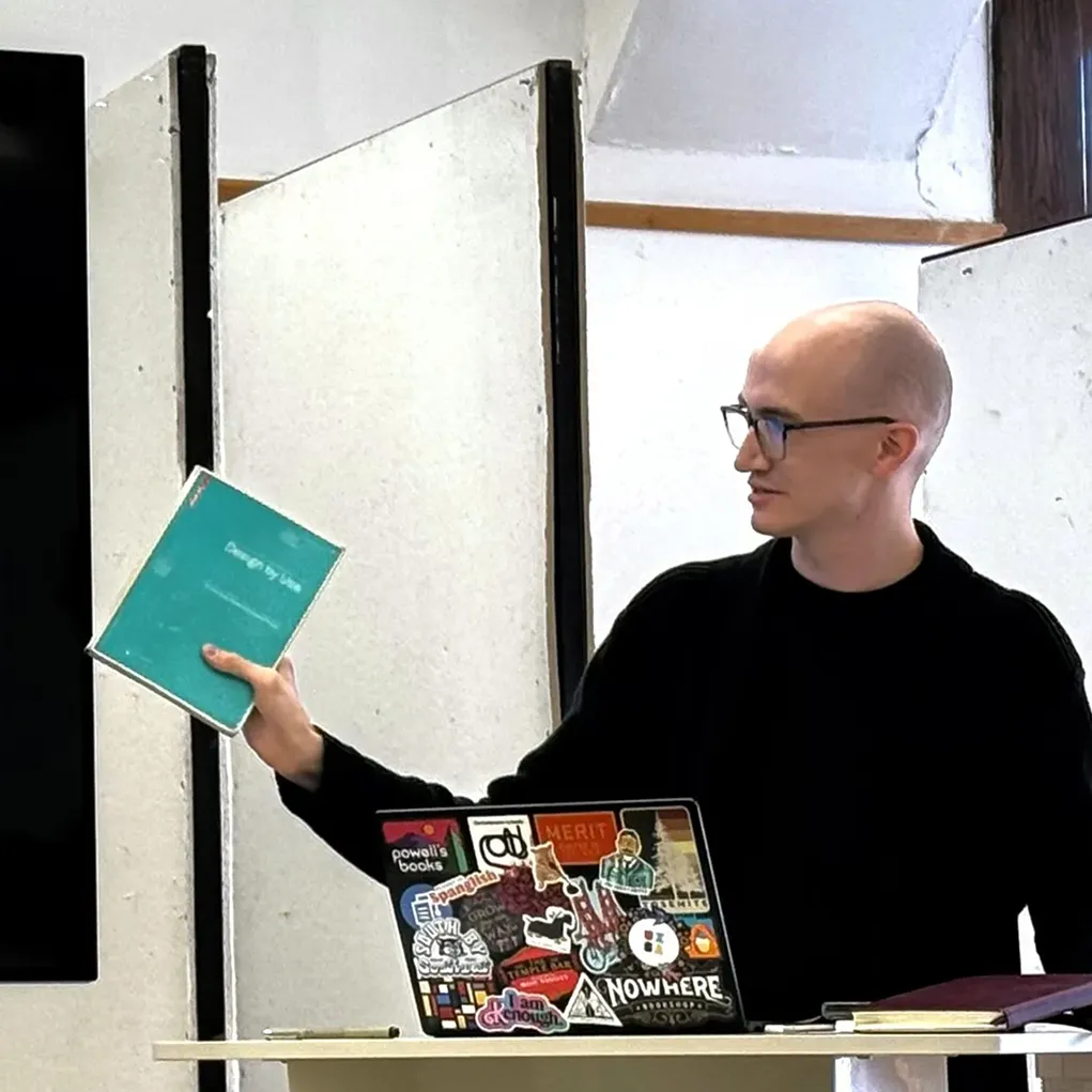 A photo of Joseph Ratliff giving a presentation while holding a book