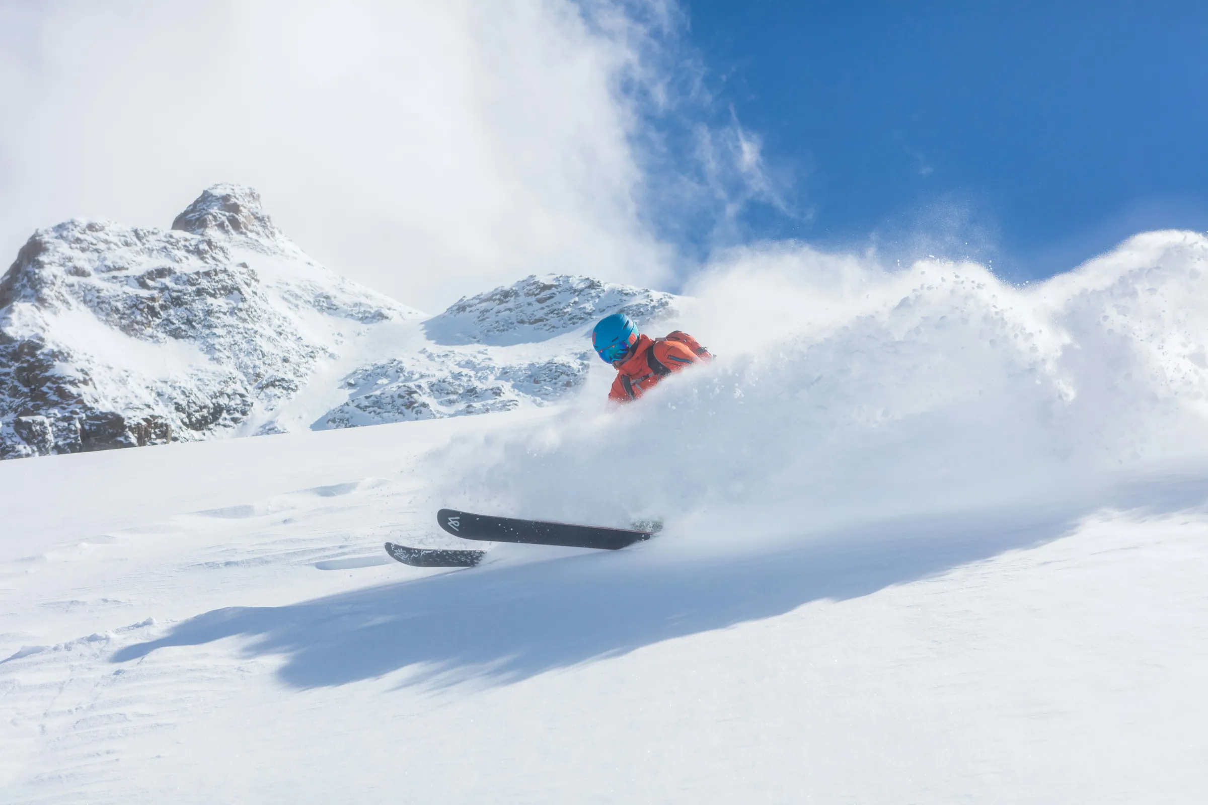 Esquiador en nieve polvo con picos nevados, viajes de esquí en grupo desde México