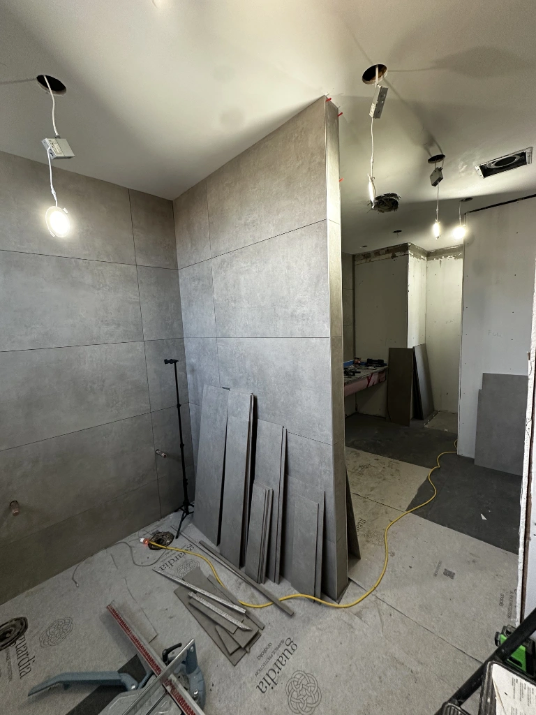 Commercial washroom renovation in progress — large-format grey tile installation mid-build in the GTA.