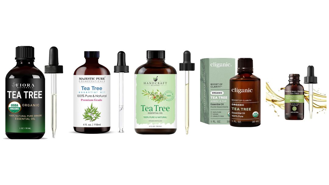 Five dark glass tea tree essential oil bottles with glass droppers and one green box on white