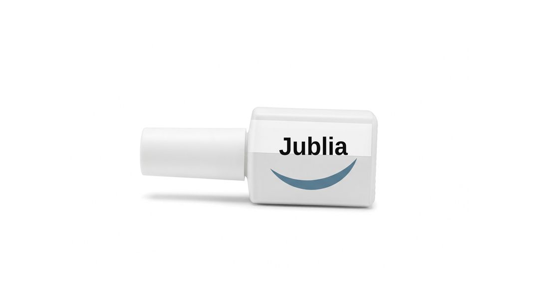 A white nail lacquer bottle on a white background, with a plain white label reading Jublia and a blue swoosh beneath it.
