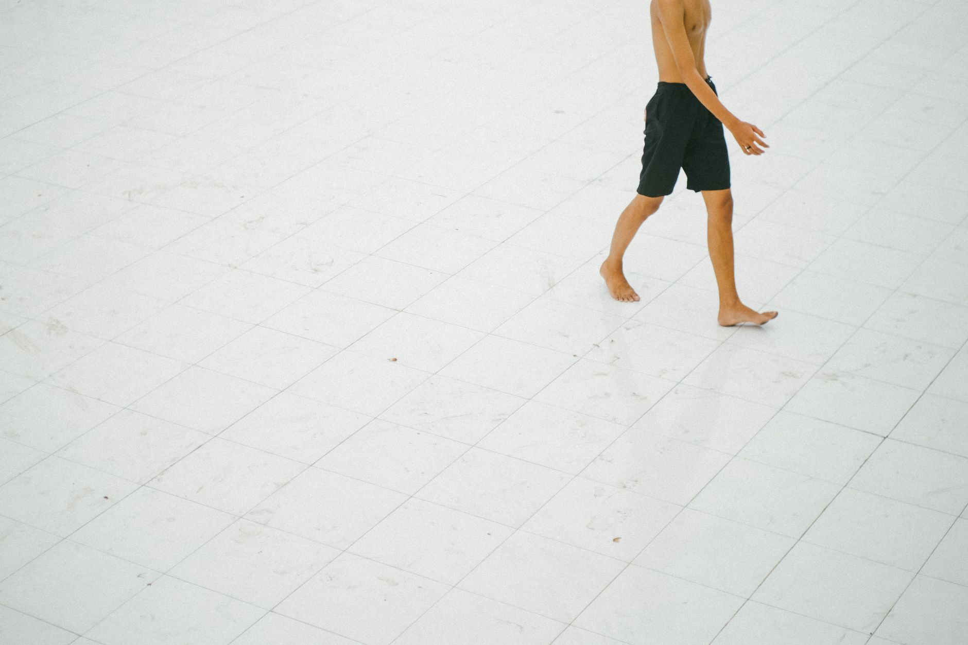 Someone walking on a pavement with weight rolled onto the outer edge of one foot.