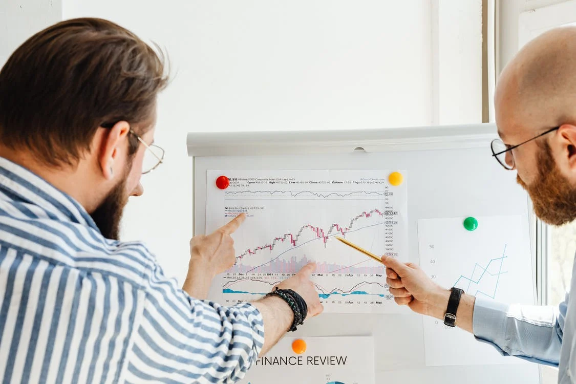 People pointing and looking at graph