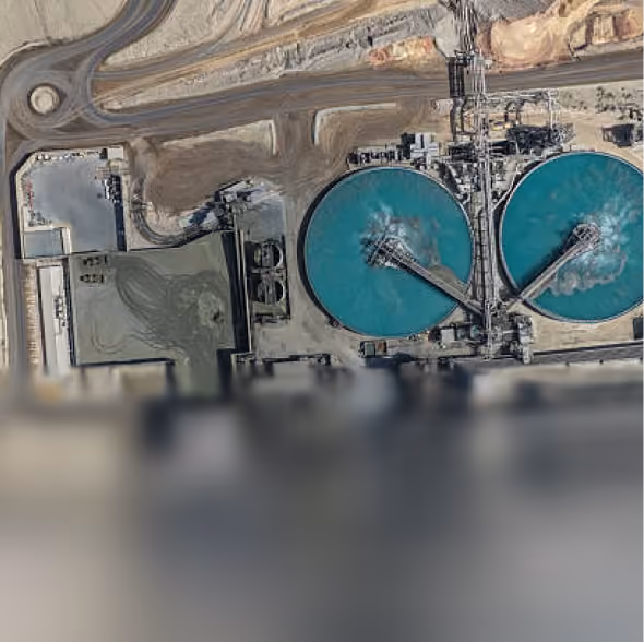 Aerial view of circular water treatment tanks and surrounding industrial structures.
