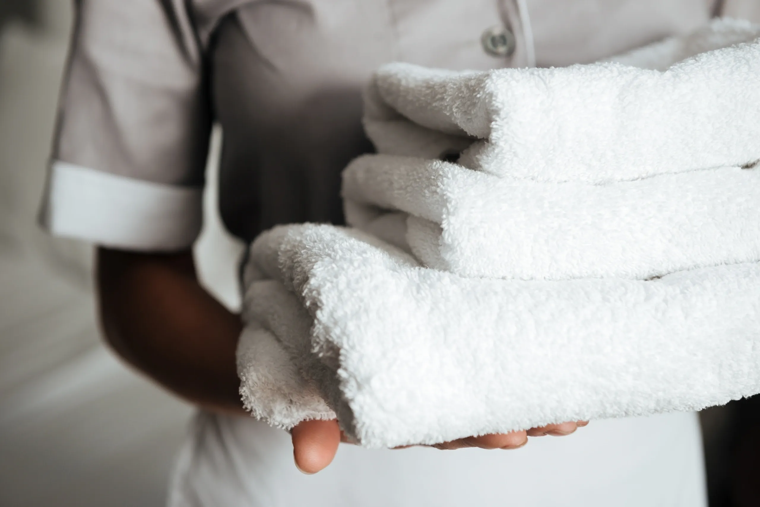 Professional housekeeping staff handling clean towels for holiday rental