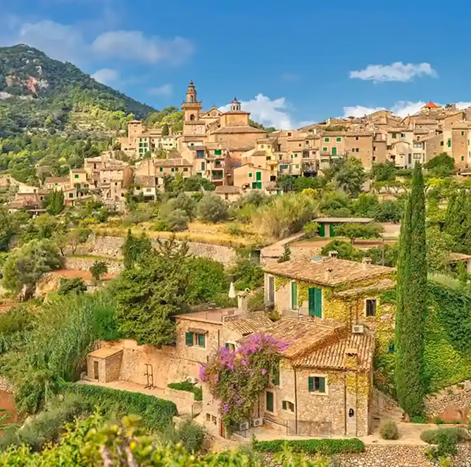 Traditional Mallorcan village surrounded by green hills and Mediterranean countryside