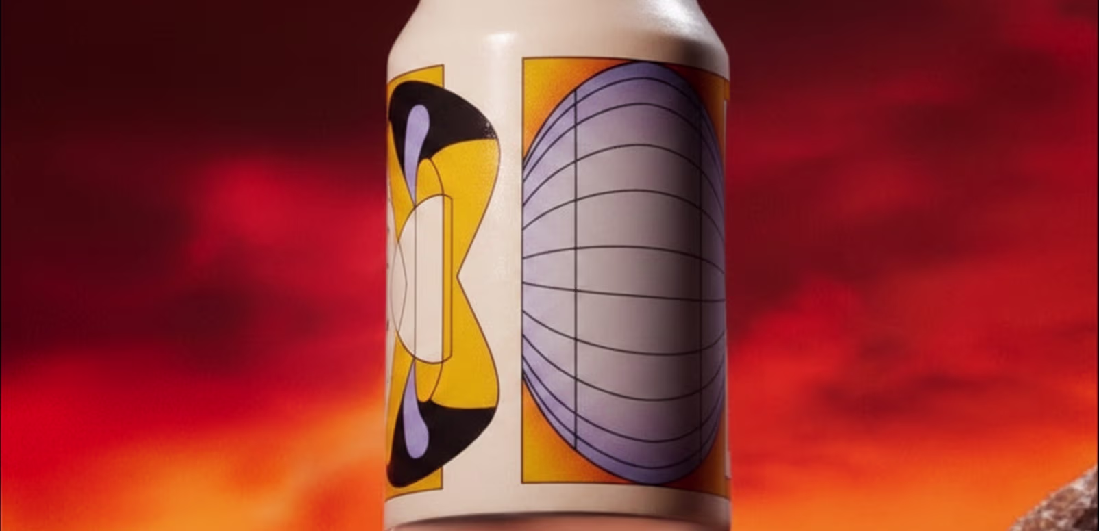 Beverage can with an abstract grid-sphere label design against a fiery orange and red sky