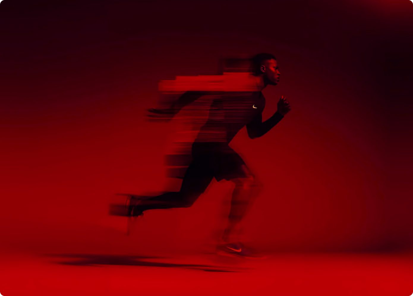 Athlete sprinting with motion blur against a vibrant red studio background