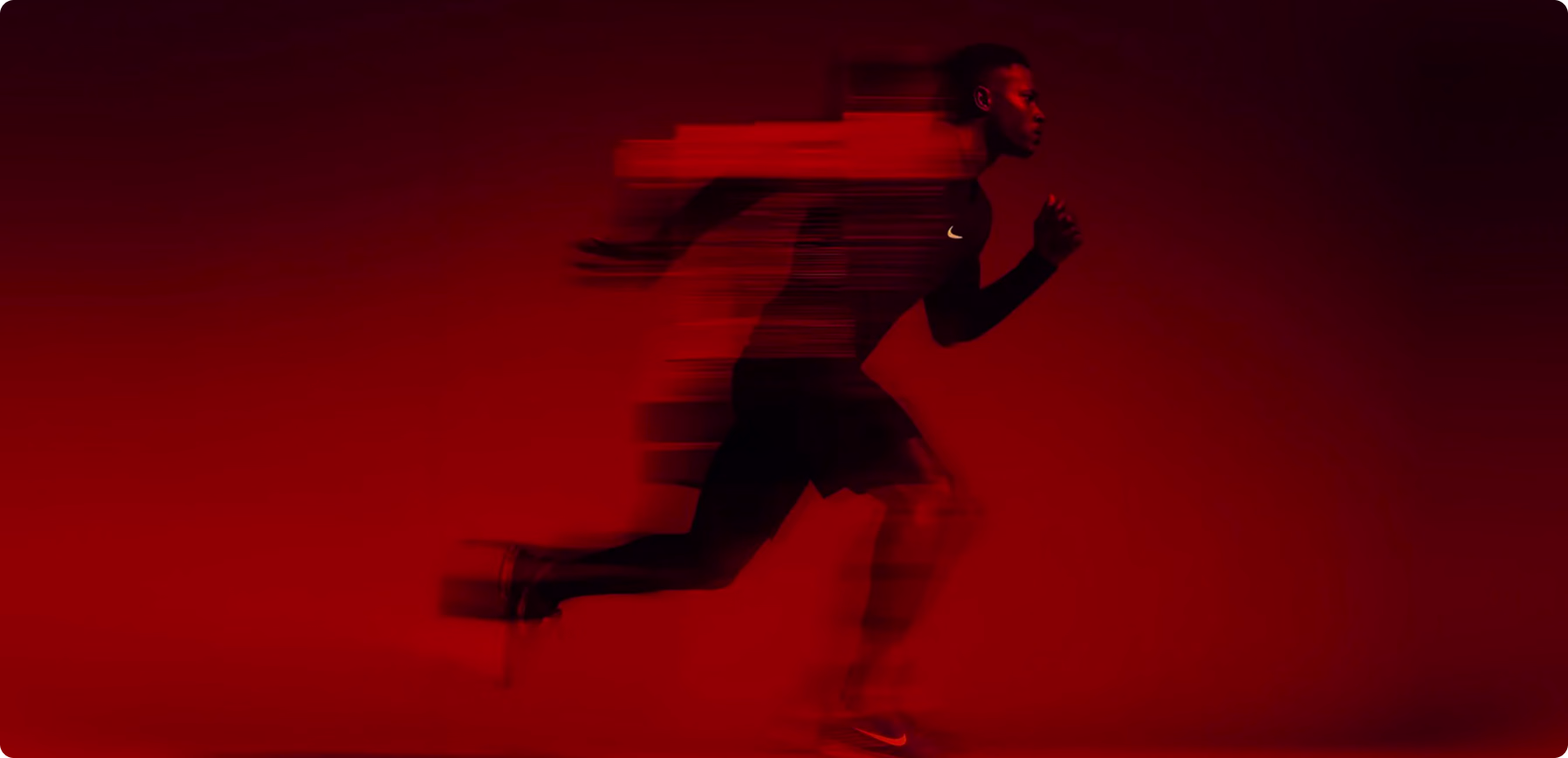 Athlete sprinting with motion blur against a vibrant red studio background