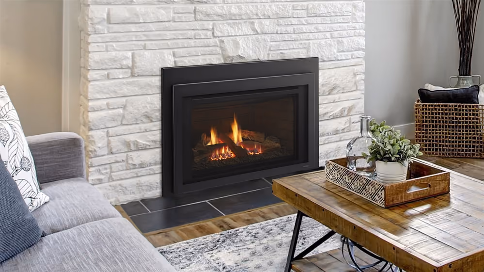 Living room with a lit modern fireplace set in white stone wall, gray sofa, and wooden coffee table.
