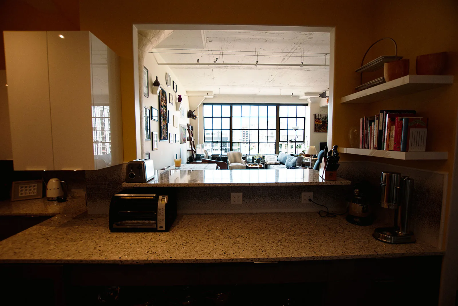 Pearl District kitchen pass-through with floating shelves and a view into the loft living room