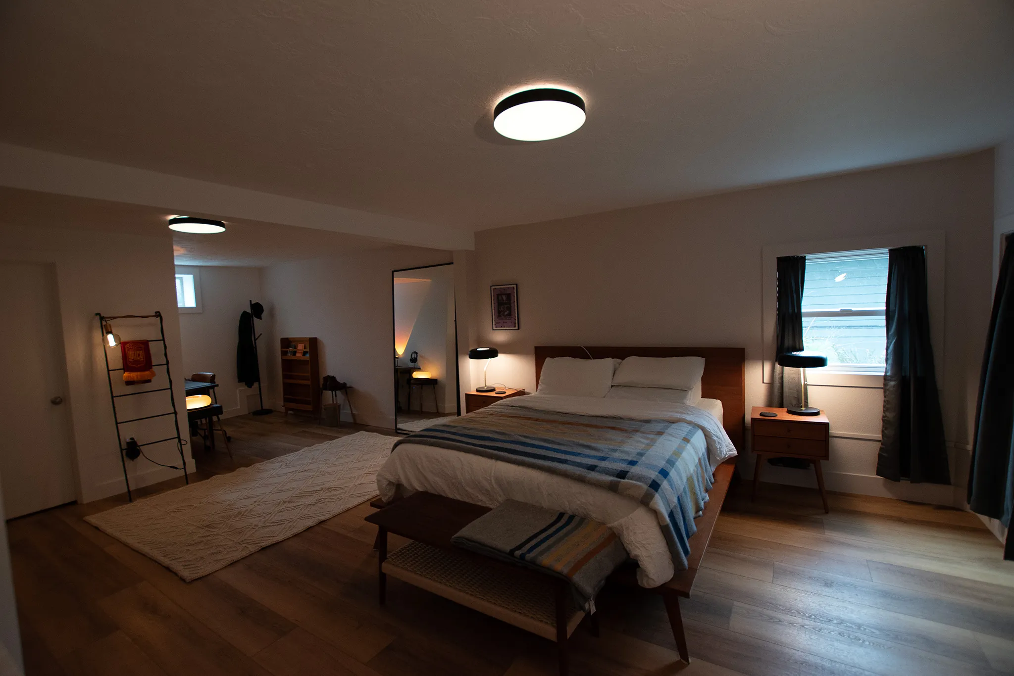Mt. Scott basement bedroom with walnut bed frame, wood-look floors, and window