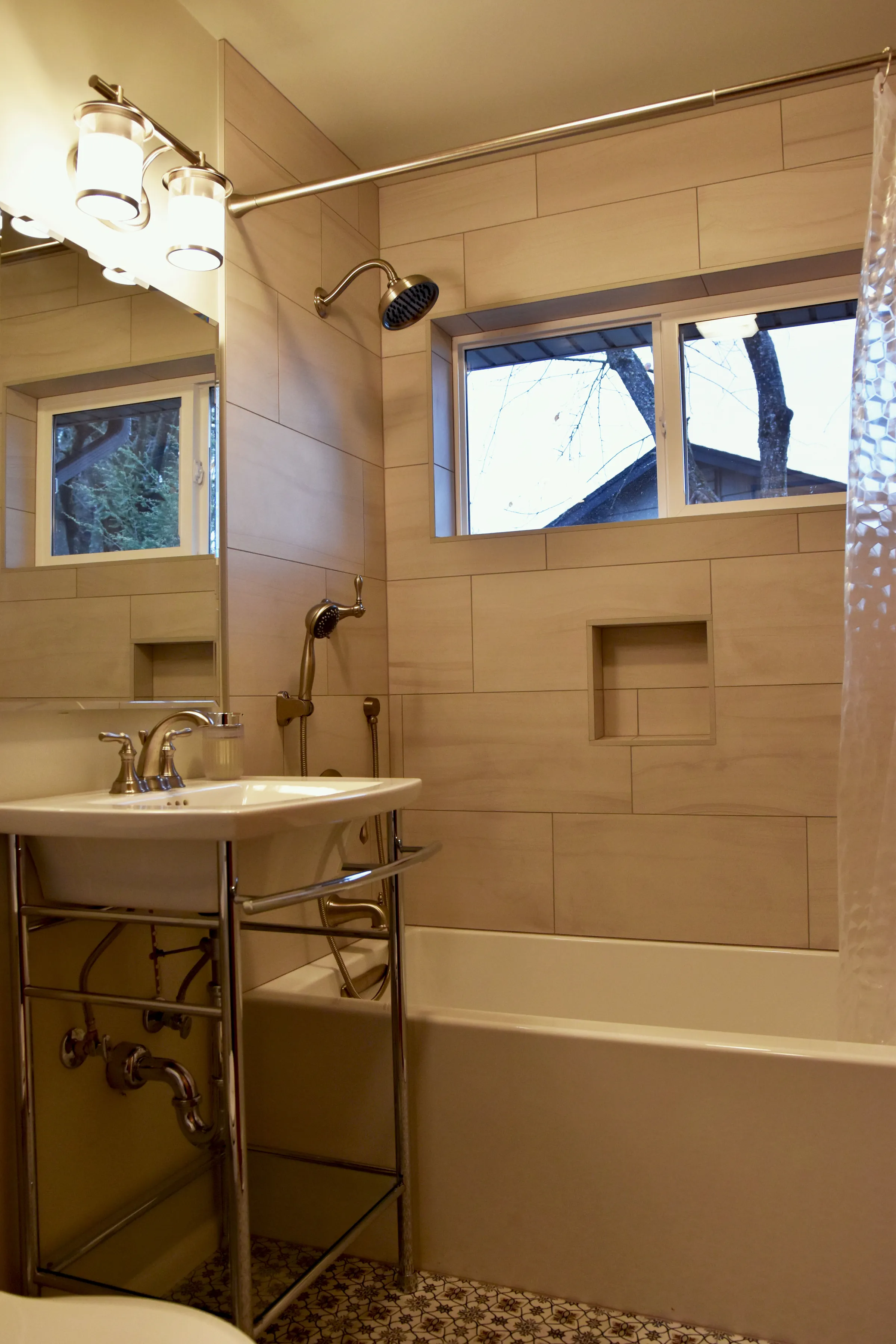 Gateway bathroom tub and shower with wood-look tile surround, recessed niche, and window above