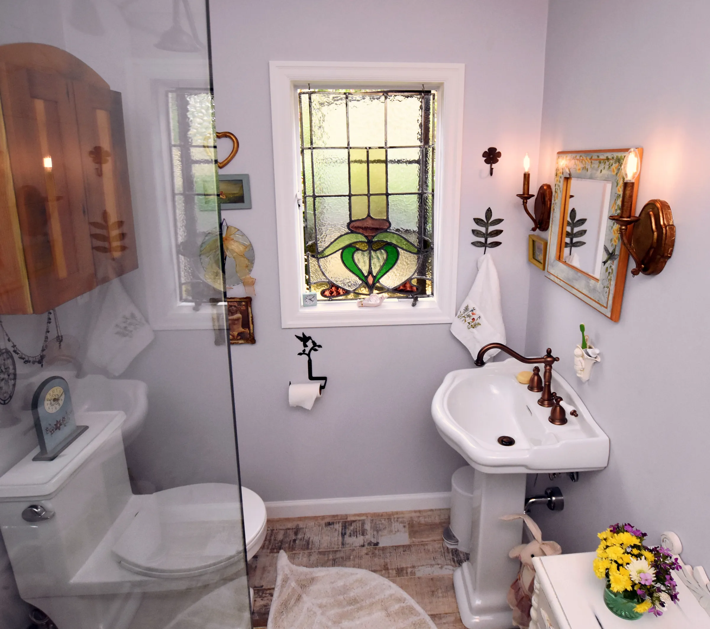 Gladstone bathroom with pedestal sink, stained glass window, toilet, and glass shower panel