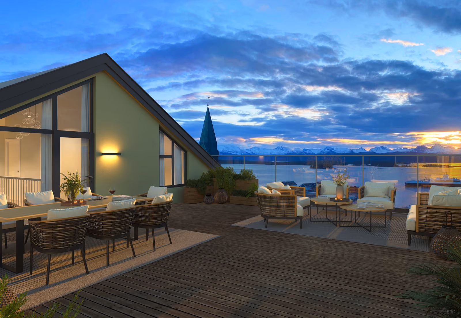 Outdoor terrace with dining and lounge areas overlooking water, mountains, and a sunset sky.
