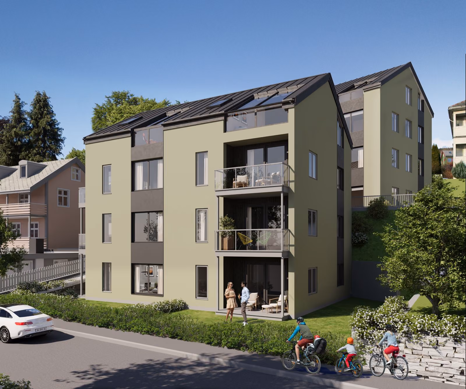Modern three-story residential building with balconies and cyclists riding on the road nearby.