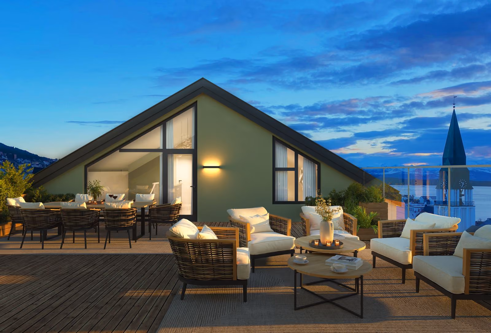 Cozy rooftop patio with cushioned wicker chairs and tables at dusk overlooking water and a church tower.
