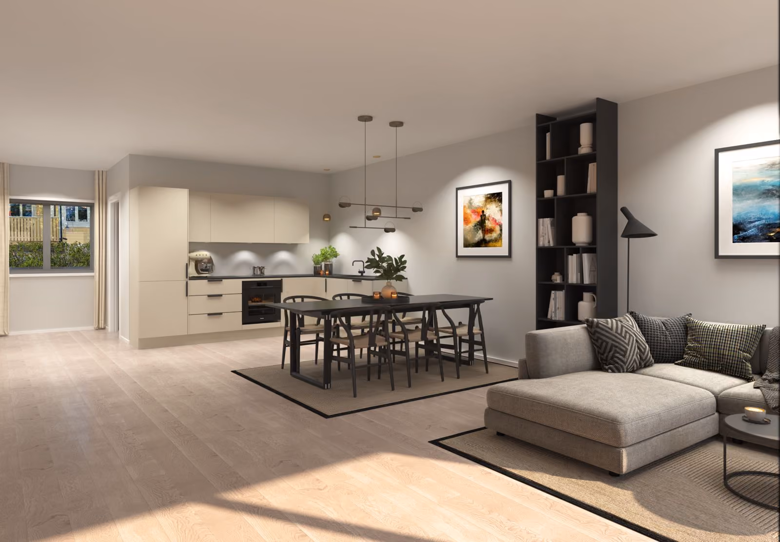 Modern open kitchen and living room with beige cabinets, dark dining table, gray sofa, and art on walls.