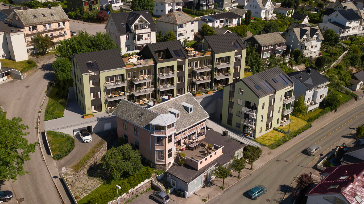 Aerial view of residential neighborhood with modern apartment buildings and older houses along streets.