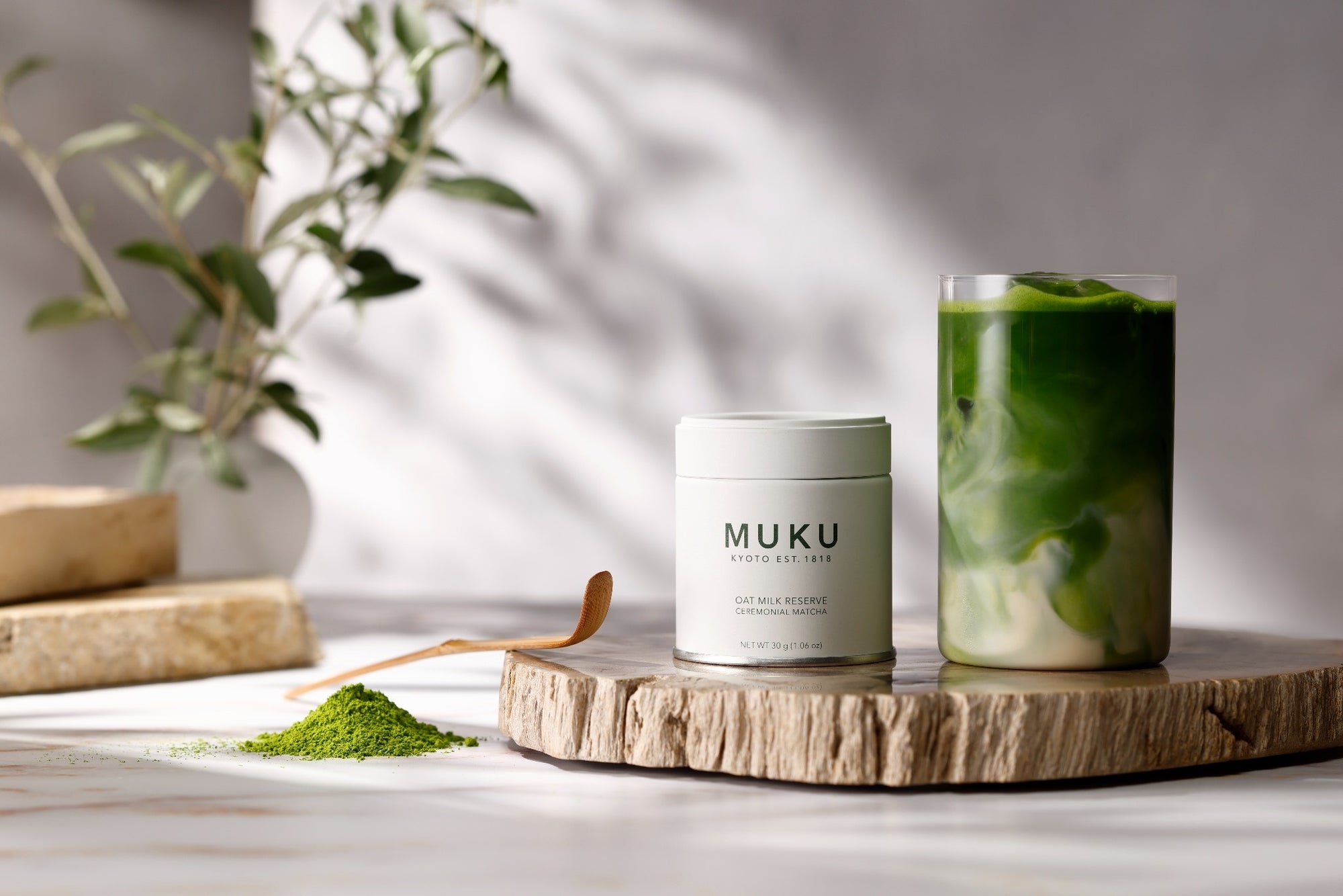 MUKU Kyoto 30g tin beside an oat milk matcha latte