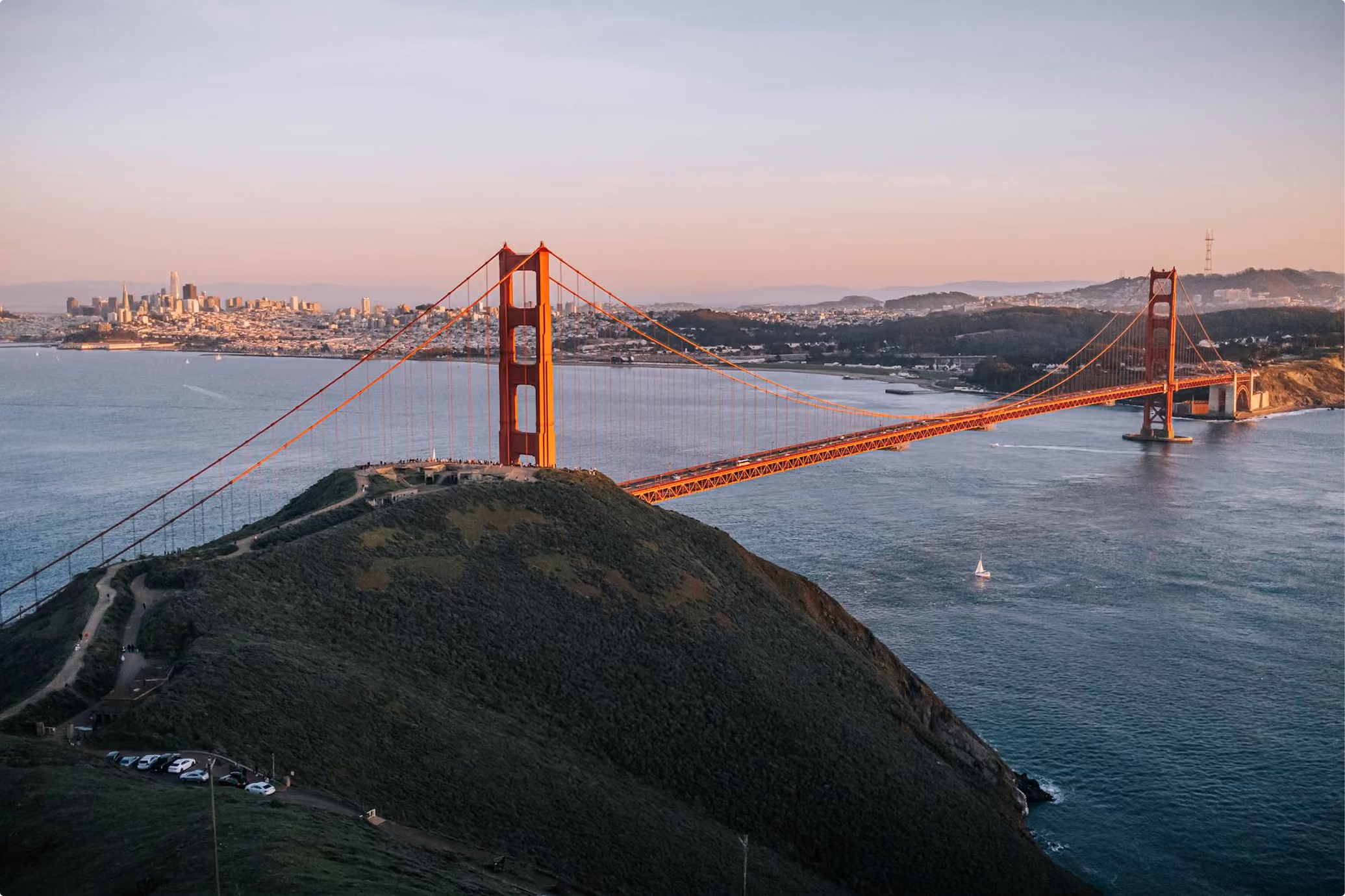 Golden Gate Bridge at sunset with the San Francisco skyline across the bay