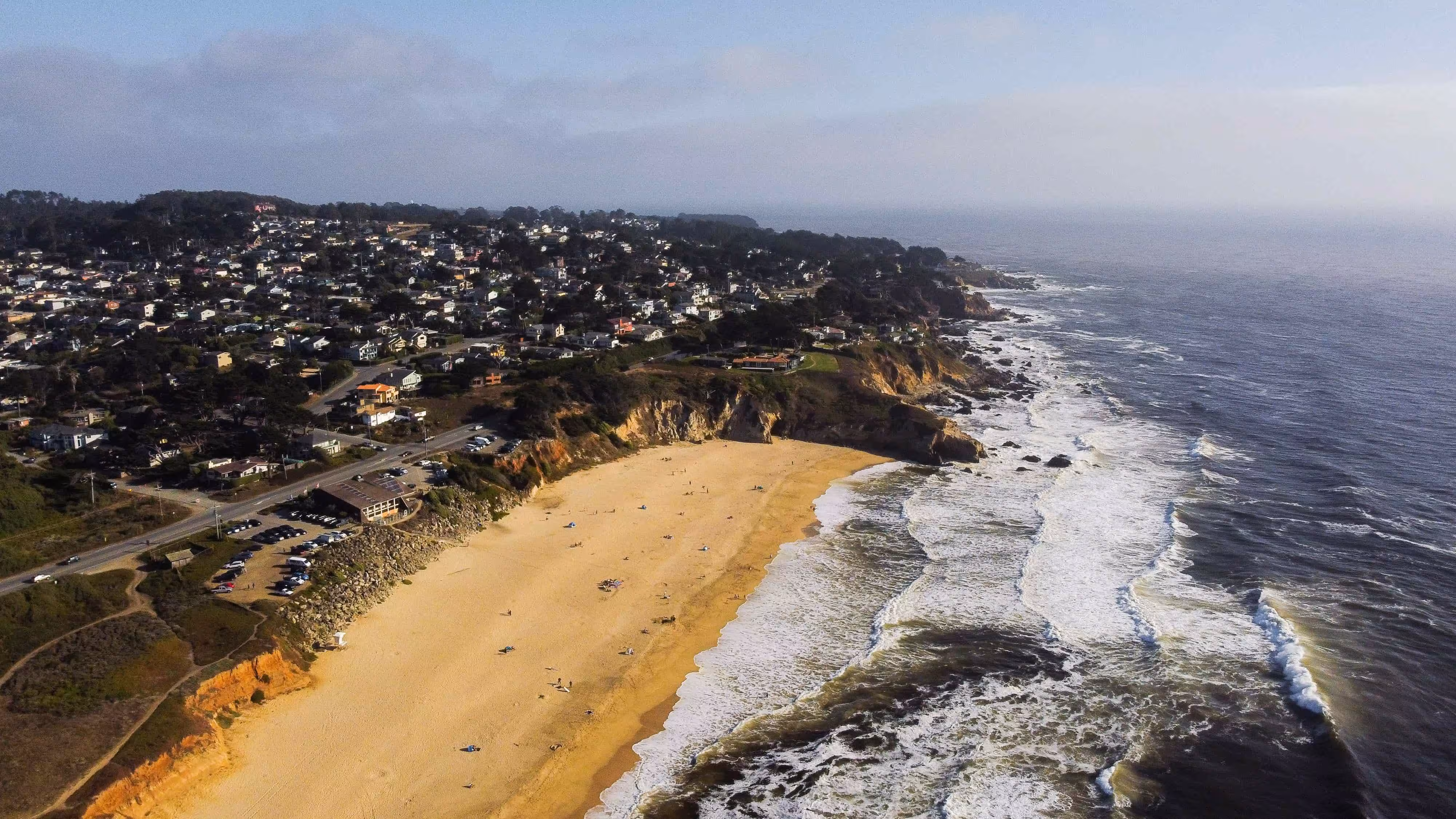Wide aerial view of a coastal town along the Pacific coastline