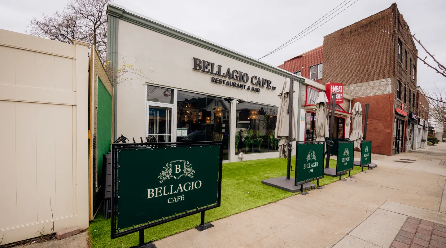 Outdoor seating area with closed umbrellas outside Bellagio Café restaurant on a city street.