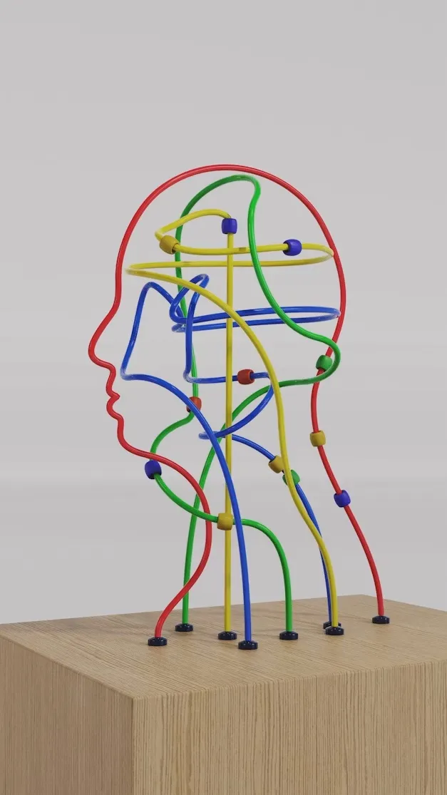 Colorful wire bead maze shaped like a human head on a wooden block pedestal.