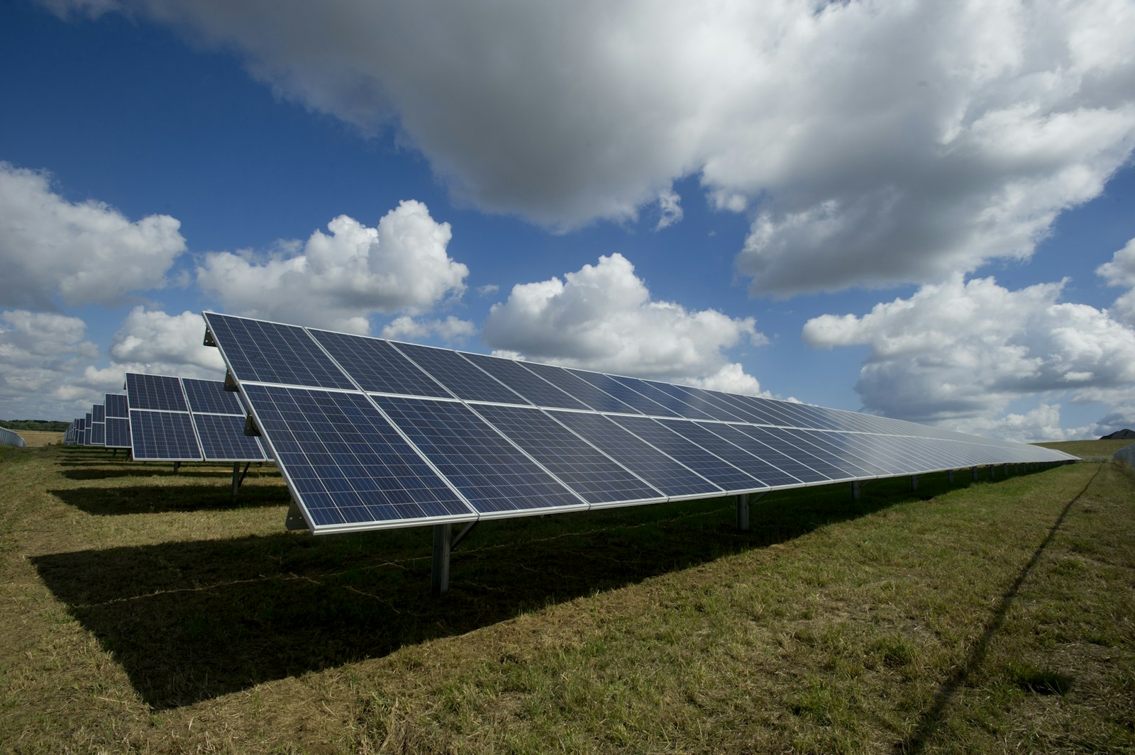 Rows of solar panels under a bright sky