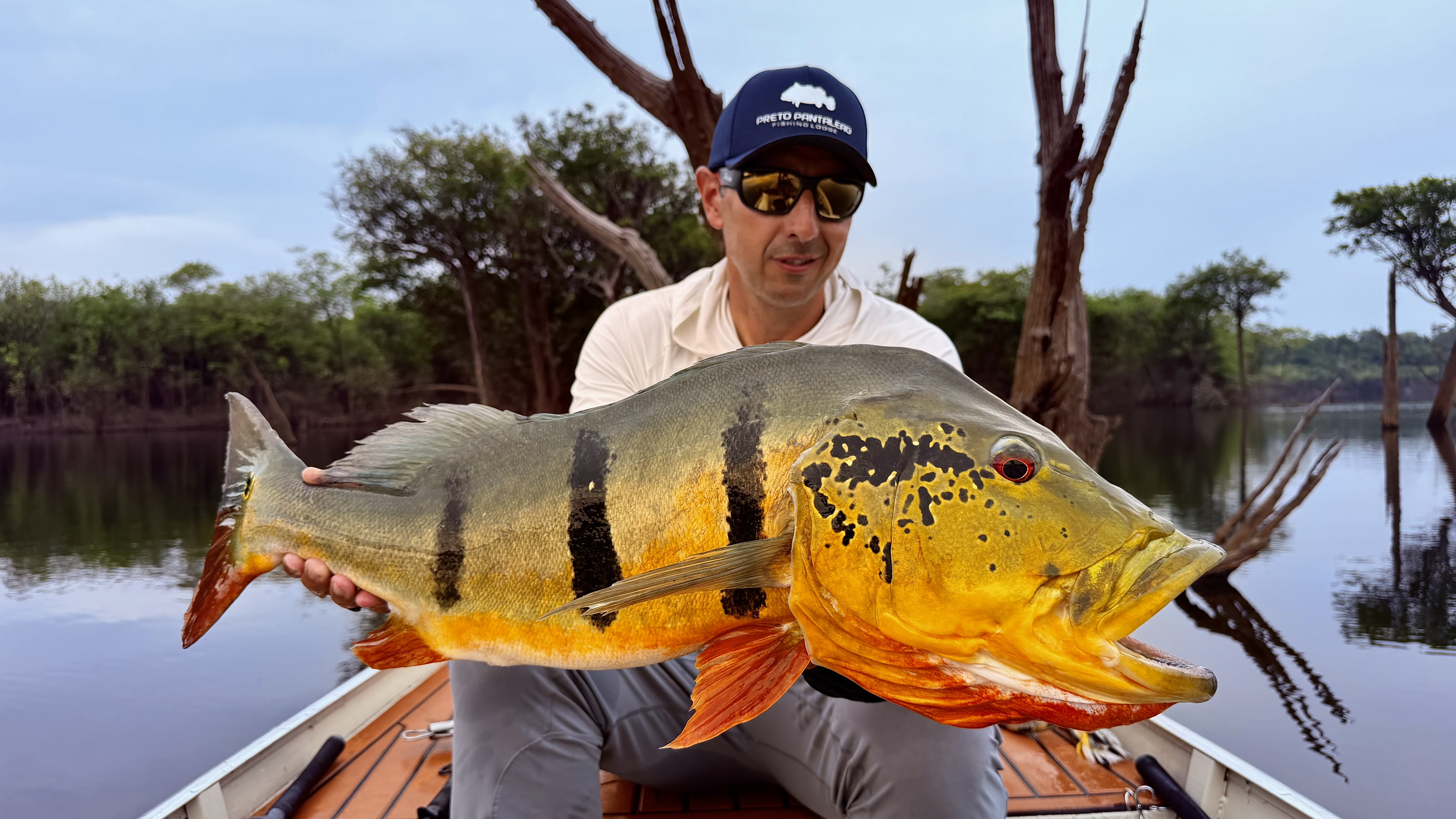 Lucas Sanchez holding a giant peacock bass in the Amazon