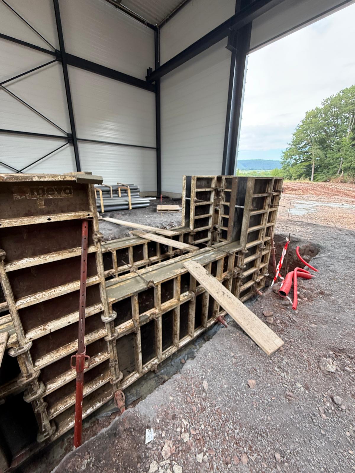 Coffrage en métal sur un chantier, à l'intérieur d'une structure métallique ouverte sur l'extérieur.