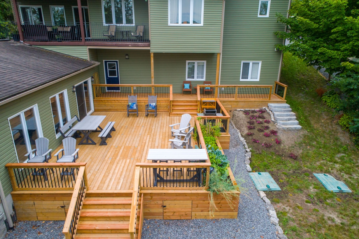 Newly stained wooden deck with outdoor furniture next to a house