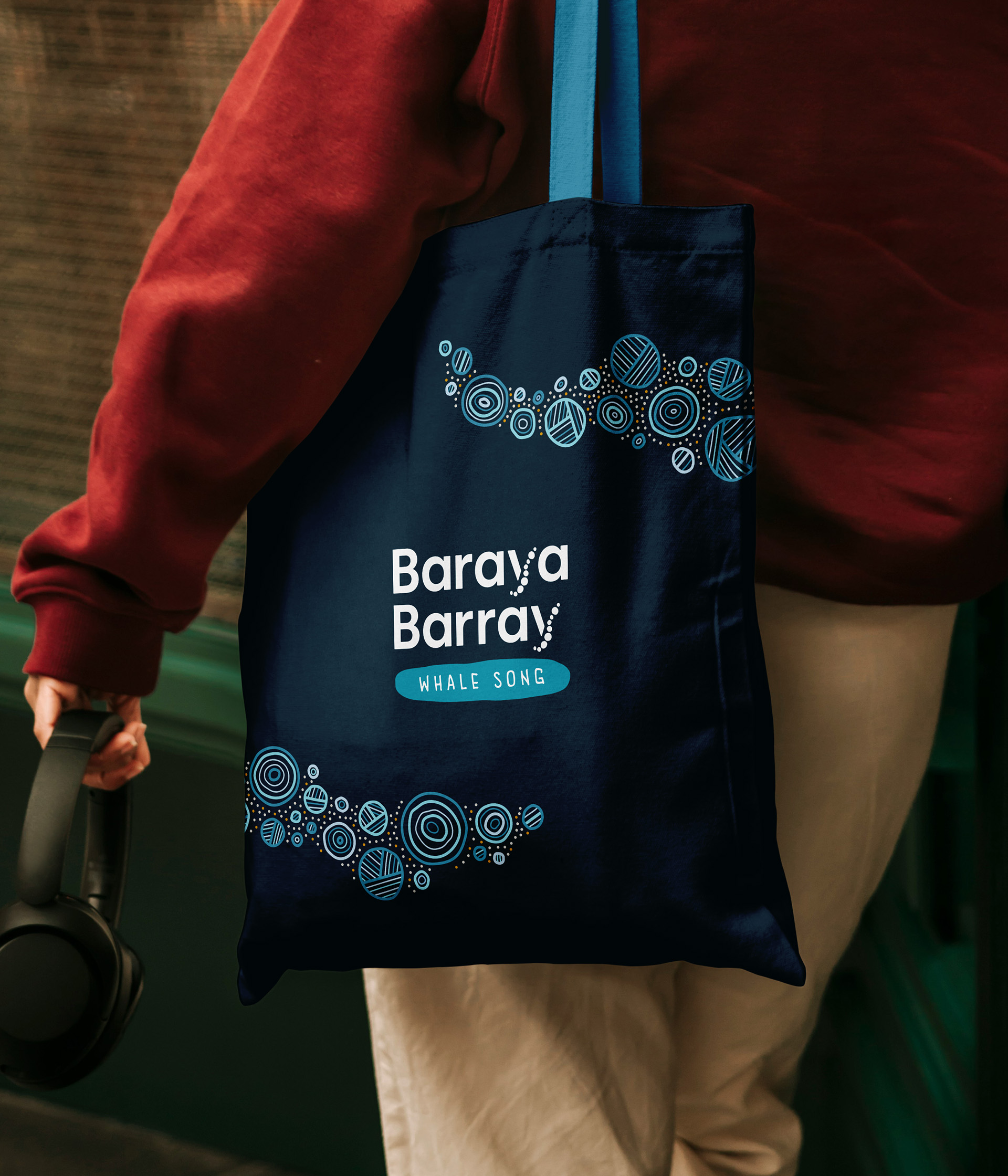 A Baraya Barray tote bag carried on the street, printed with the logo and whale migration pattern