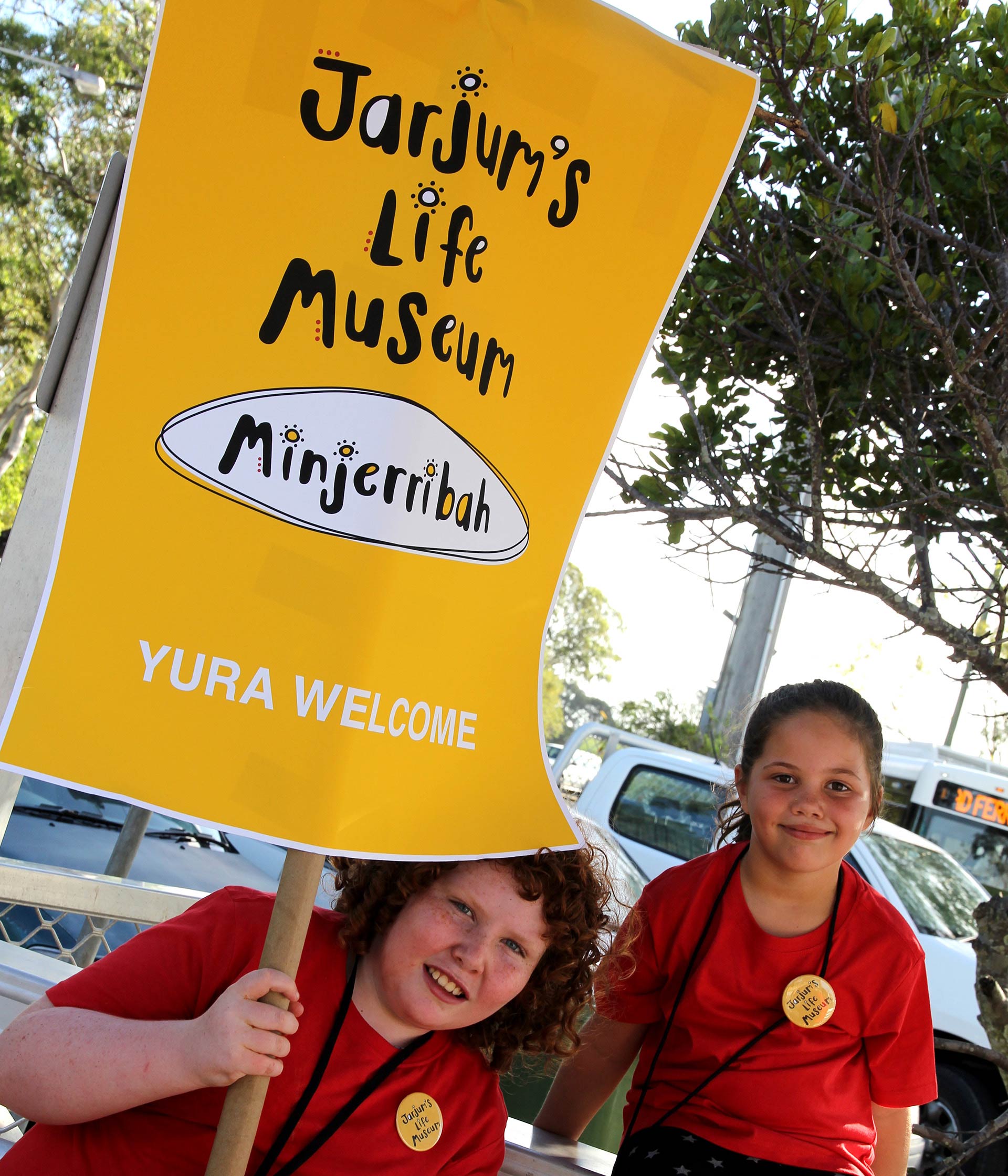 Two children holding a Jarjum's Life Museum Minjerribah welcome sign