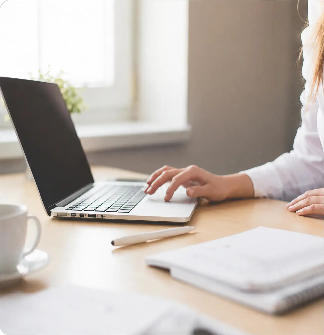 Digitale Steuerberatung am Laptop mit Unterlagen auf dem Schreibtisch