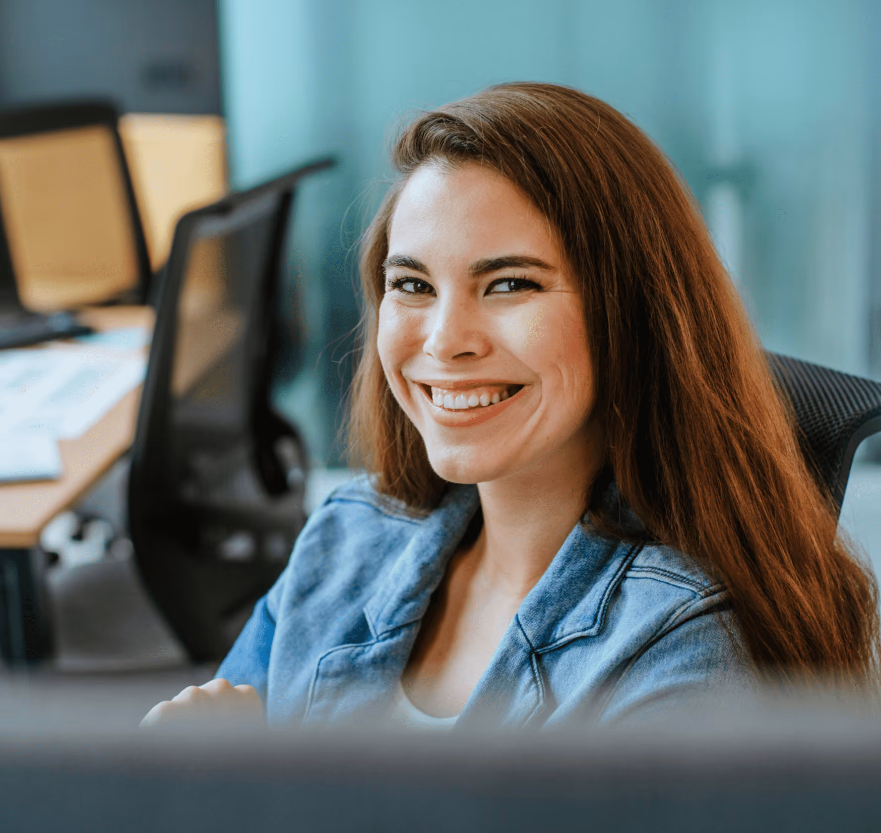 Person smiling at their desk in an office