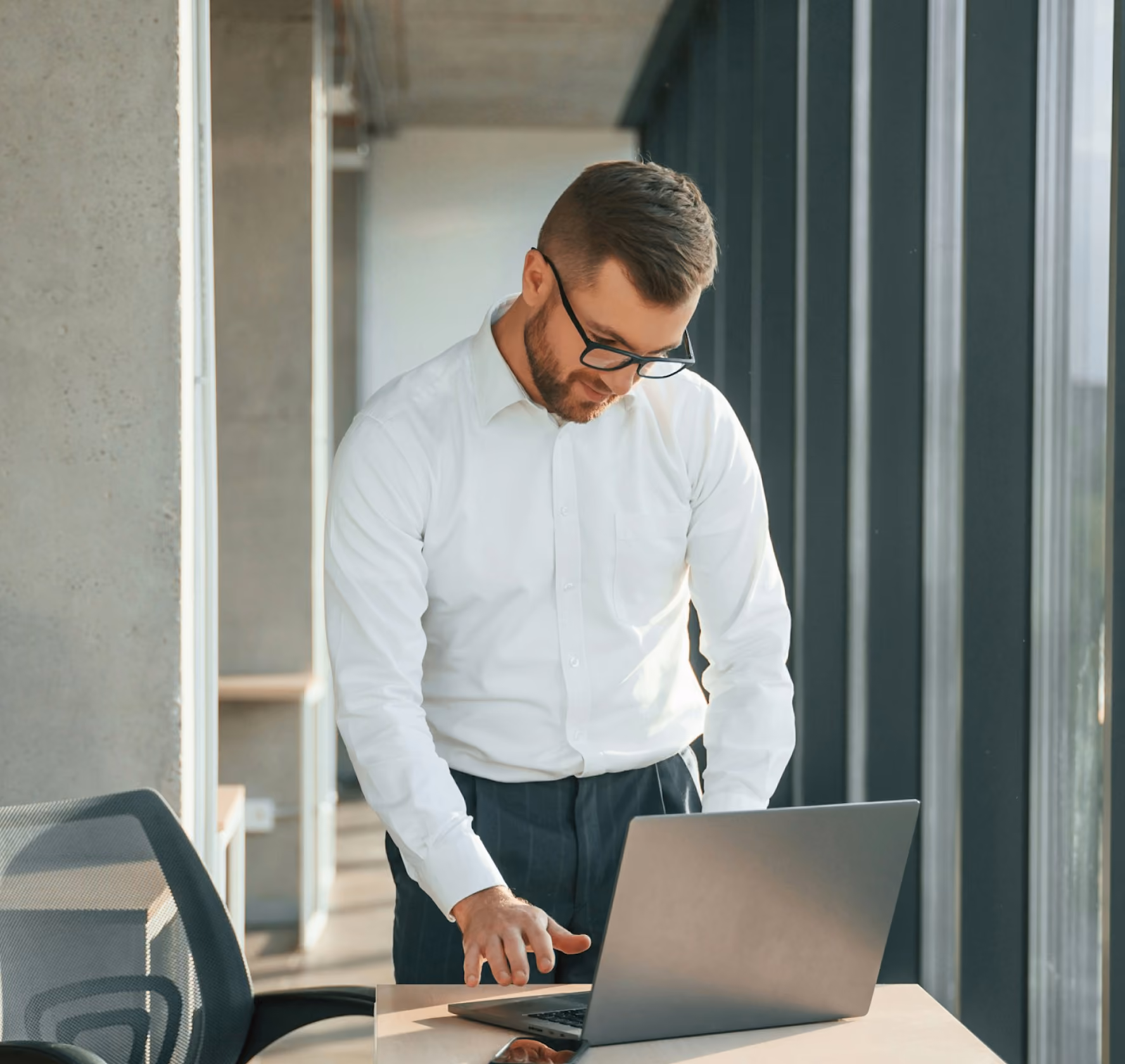 Person using a laptop while standing in an office