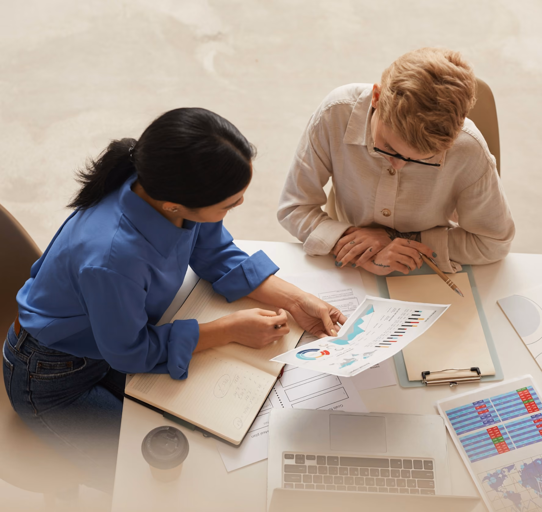 Two colleagues reviewing printed charts and reports together