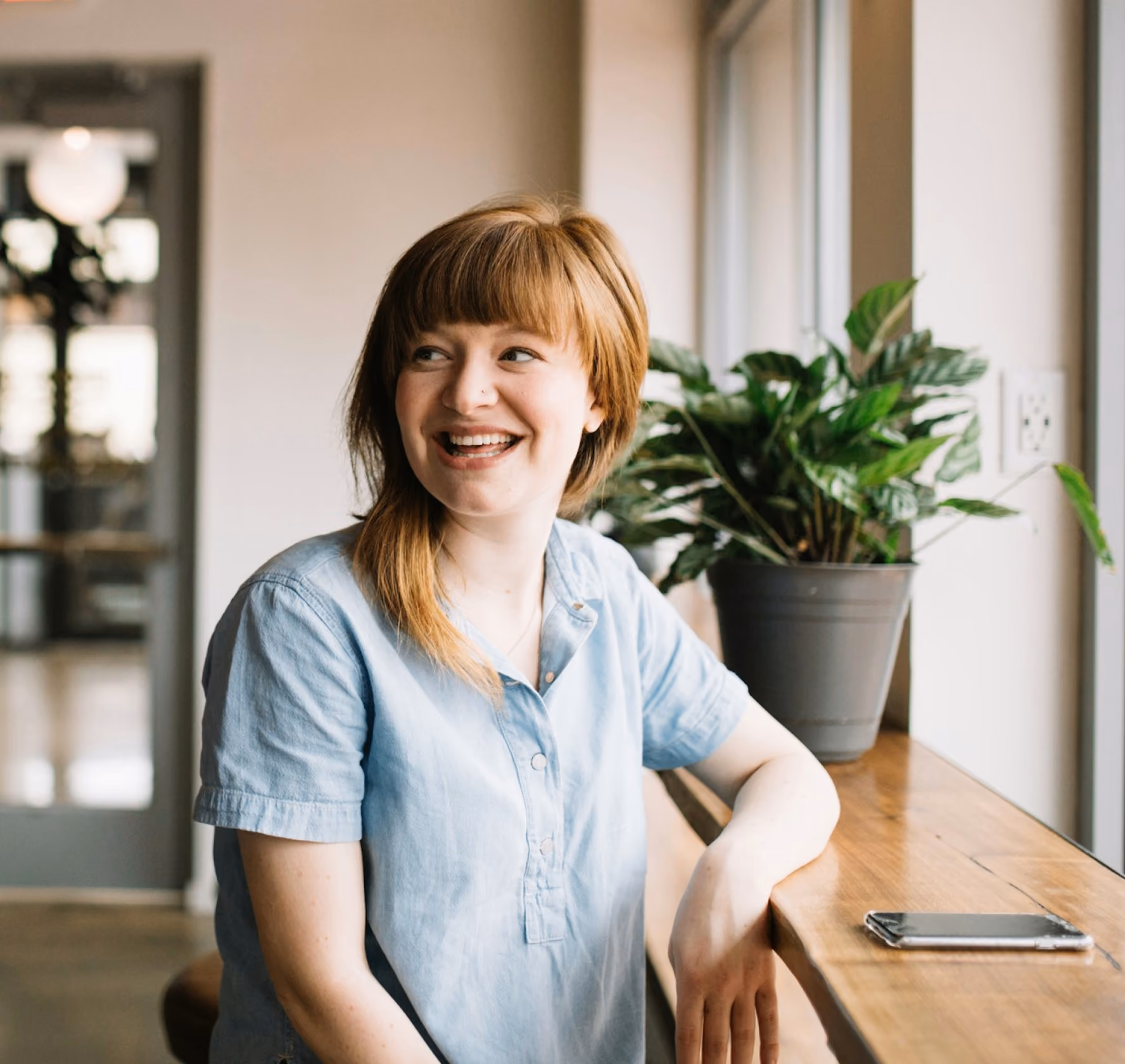 Person smiling by a window in an office