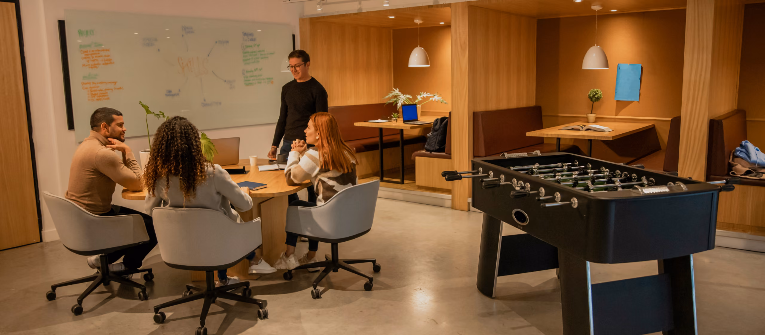 Team meeting around a whiteboard in a modern coworking office