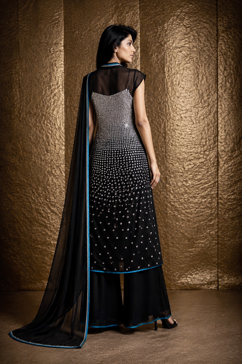 Back view of black couture ensemble with graduated silver embellishment from Silver Eclipse by Alia Qureshi Atelier