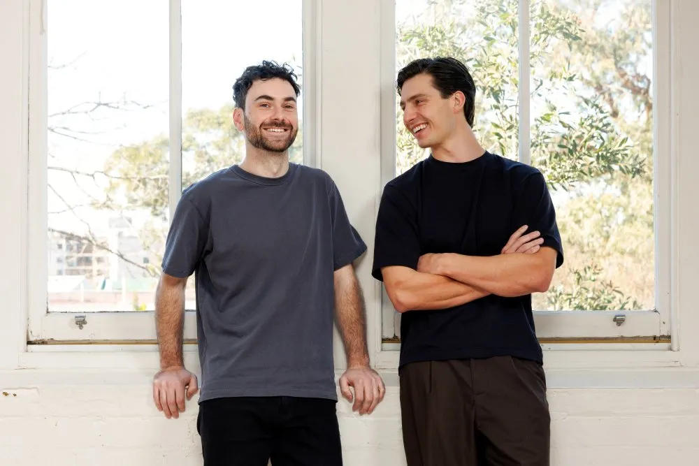 Photo of Alex and Pat smiling in front of a window