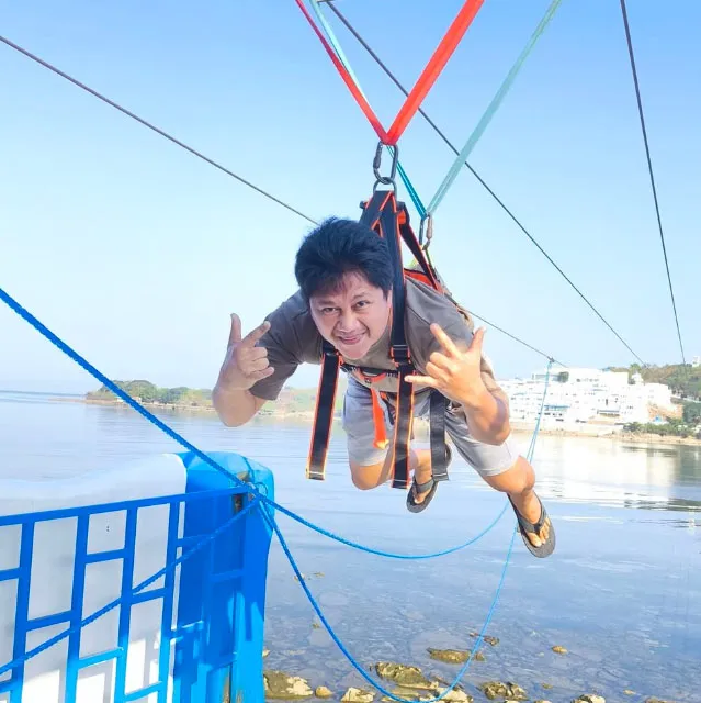 An image of Tomas on a hang gliding ride.